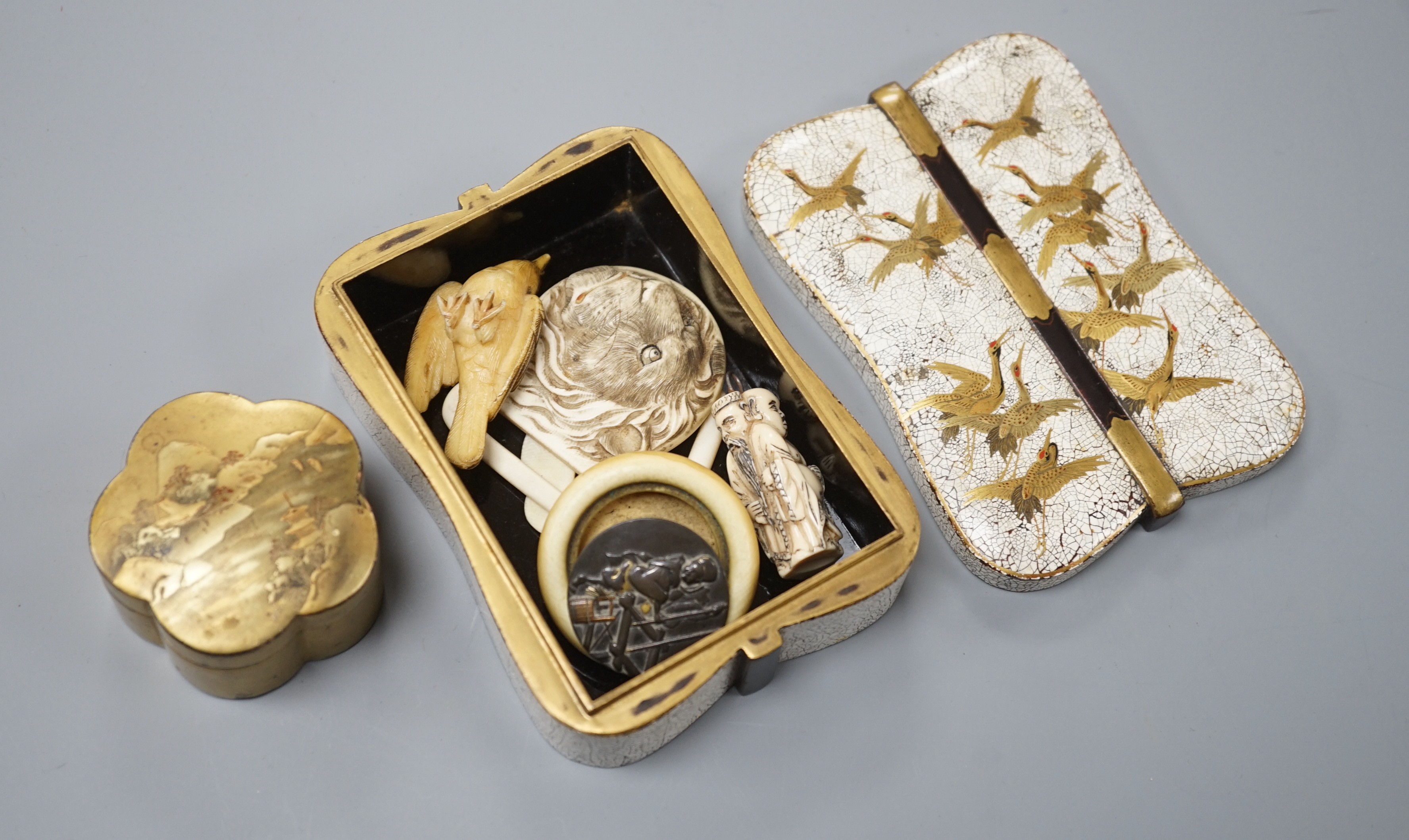 Two Japanese lacquer boxes, an ivory and bronze manju, an ivory ‘lion’ two-piece belt buckle and two simulated ivory items, late 19th/early 20th century, largest Box 11.5 cm